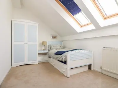 a bedroom with a white bed and a skylight at Riverview in Lostwithiel