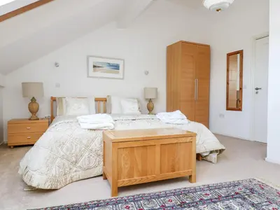 a bedroom with a large bed with a wooden dresser at Riverview in Lostwithiel
