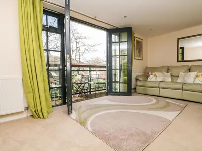 a living room with a couch and a large window at Riverview in Lostwithiel