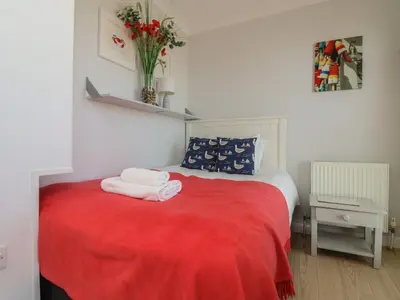 a bedroom with a red bed with a red blanket at Tides in Padstow