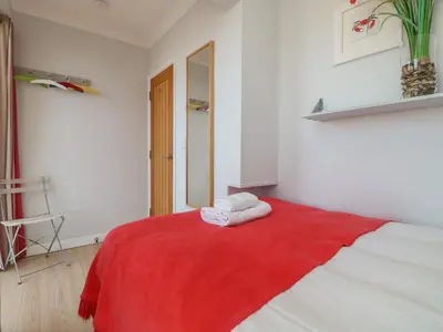 a room with a red blanket on a bed at Tides in Padstow