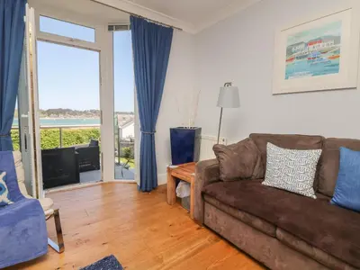 a living room with a couch and a sliding glass door at Tides in Padstow