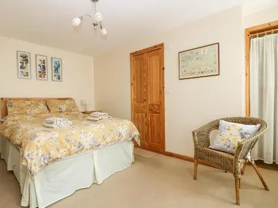 a bedroom with a bed and a chair at Mynheer Farm Bowji in Redruth