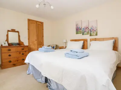 a bedroom with two beds and a dresser at Mynheer Farm Bowji in Redruth