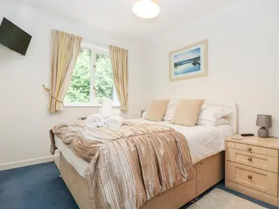 a bedroom with a large bed and a window at Rosemary Cottage in Falmouth