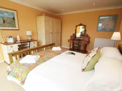 a bedroom with a white bed with a pillow on it at Windrush in Newquay