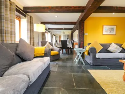a living room with couches and a dining room at Marhayes in Camelford