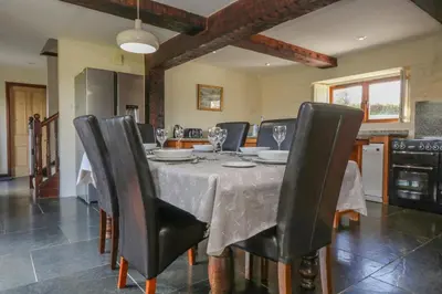 a dining room with a table with black chairs at Marhayes in Camelford