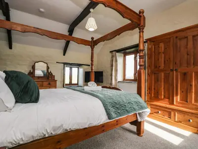 a bedroom with a wooden canopy bed in a room at Westhayes in Camelford