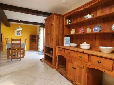 a kitchen with wooden cabinets and a dining room at Westhayes in Camelford