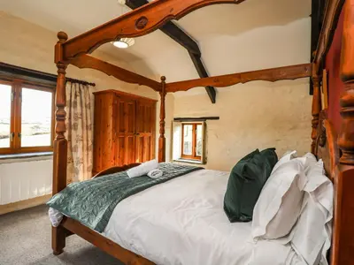 a bedroom with a large wooden canopy bed at Westhayes in Camelford