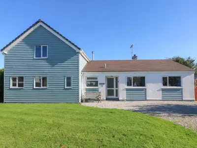 a blue and white house with a yard at Penhaven in Bude