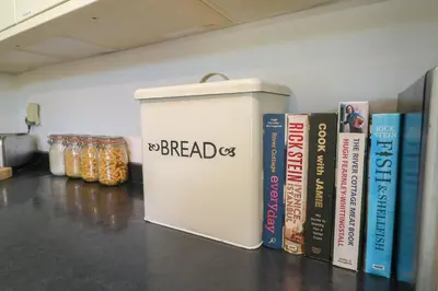 a shelf with books and a box with the words breadds at Penhaven in Bude
