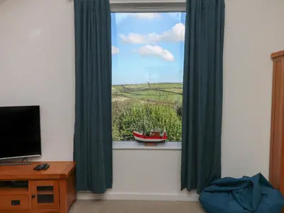 a room with a window with a view of a boat at Penhaven in Bude