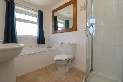 a bathroom with a toilet and a sink and a mirror at Penhaven in Bude