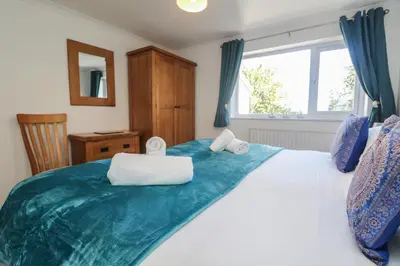 a bedroom with a large bed with a window at Penhaven in Bude