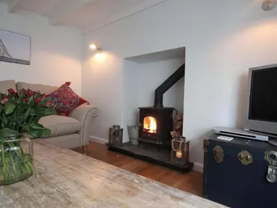 a living room with a fireplace and a couch at Trelan in St Austell