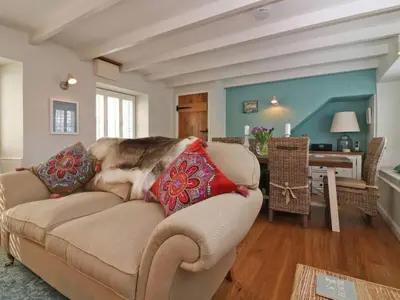 a dog sitting on a couch in a living room at Trelan in St Austell