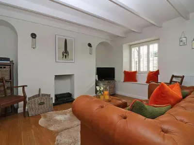 a living room with a couch and a fireplace at Trelan in St Austell