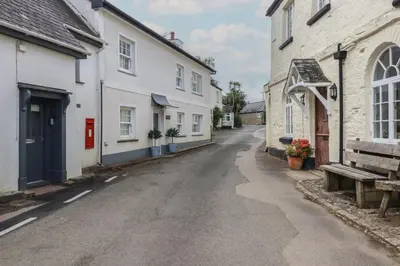 an empty street in a town with white buildings at Trelan in St Austell