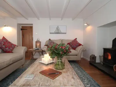 a living room with a couch and a table with candles at Trelan in St Austell