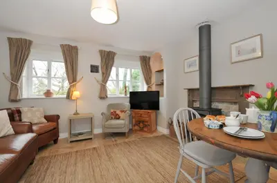 a living room with a couch a table and a fireplace at Stocks Barn in Liskeard