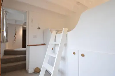 a ladder leading up to a room with a bunk bed at Stocks Barn in Liskeard