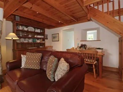 a living room with a brown leather couch and a table at Halvosso in Penryn