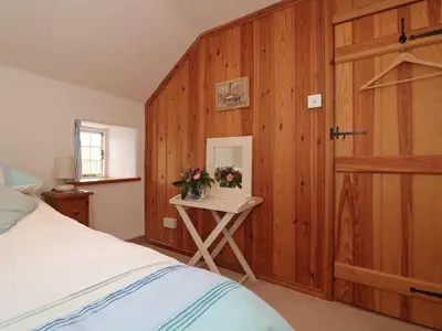 a bedroom with a bed and a table with flowers at Halvosso in Penryn