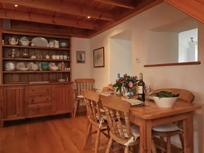 a dining room with a wooden table and chairs at Halvosso in Penryn