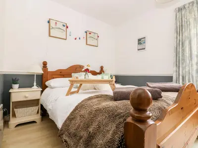 a bedroom with a bed and a table on it at Little Beach House in St Austell