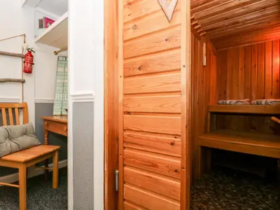 a wooden door in a room with a desk and a chair at Little Beach House in St Austell