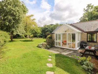 a cottage with a garden and a patio at Tre Pol Pen in Falmouth