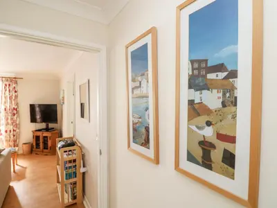a hallway with two framed paintings on the wall at Tre Pol Pen in Falmouth
