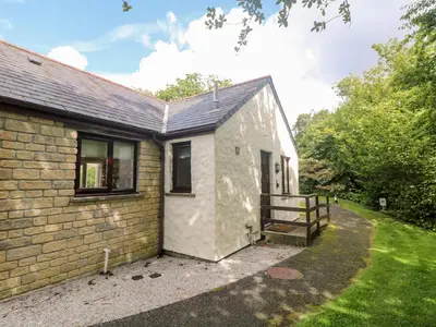 a small white house with a wooden fence at Tre Pol Pen in Falmouth