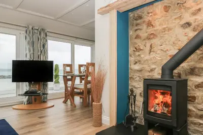 a living room with a fireplace and a television at Higher Mount View in Marazion