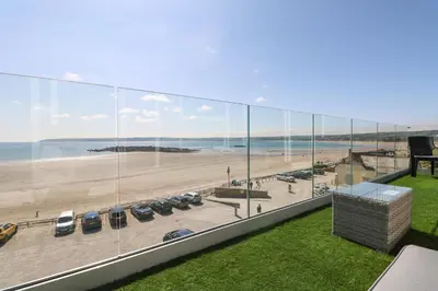 a view of the beach from the balcony of a building at Higher Mount View in Marazion