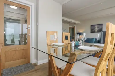 a dining room with a glass table and chairs at Higher Mount View in Marazion