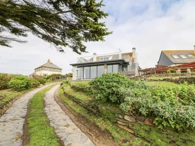 a house on a hill with a dirt road at Little Trelawns in Mawgan Porth