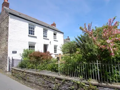 a white house with a fence in front of it at Jordan House in Boscastle