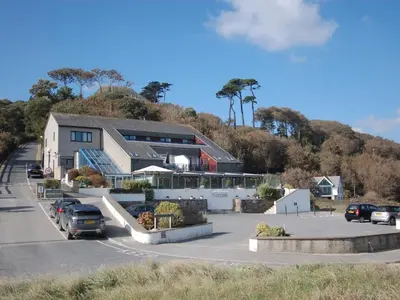 a building with cars parked in a parking lot at Pine Cottage in Falmouth