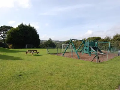 a park with a playground and a picnic table at Pine Cottage in Falmouth