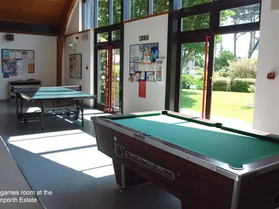 a pool table in a room with two ping pong tables at Pine Cottage in Falmouth