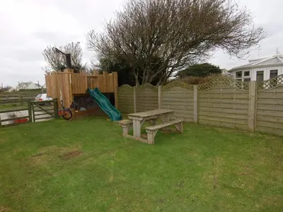 a backyard with a picnic table and a fence at Hideaway in Tintagel