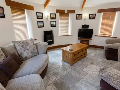 a living room with a couch and a tv at Hideaway in Tintagel