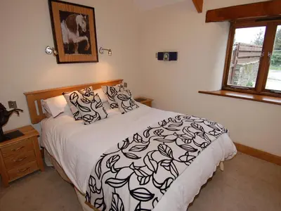 a bedroom with a bed with a black and white comforter at Hideaway in Tintagel