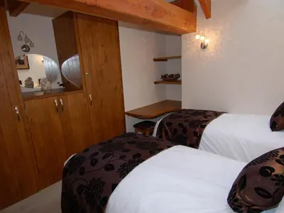 a hotel room with two beds and wooden cabinets at Hideaway in Tintagel