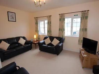 a living room with two leather couches and a television at The Barn in Camelford