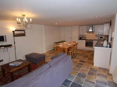 a living room with a couch and a table at The Barn in Camelford
