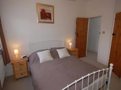 a bedroom with a large bed with two lamps on tables at The Barn in Camelford